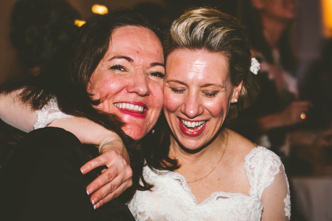 bride hugs friend on dance floor 