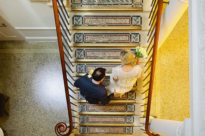 bride and groom on stairs of royal society arts london