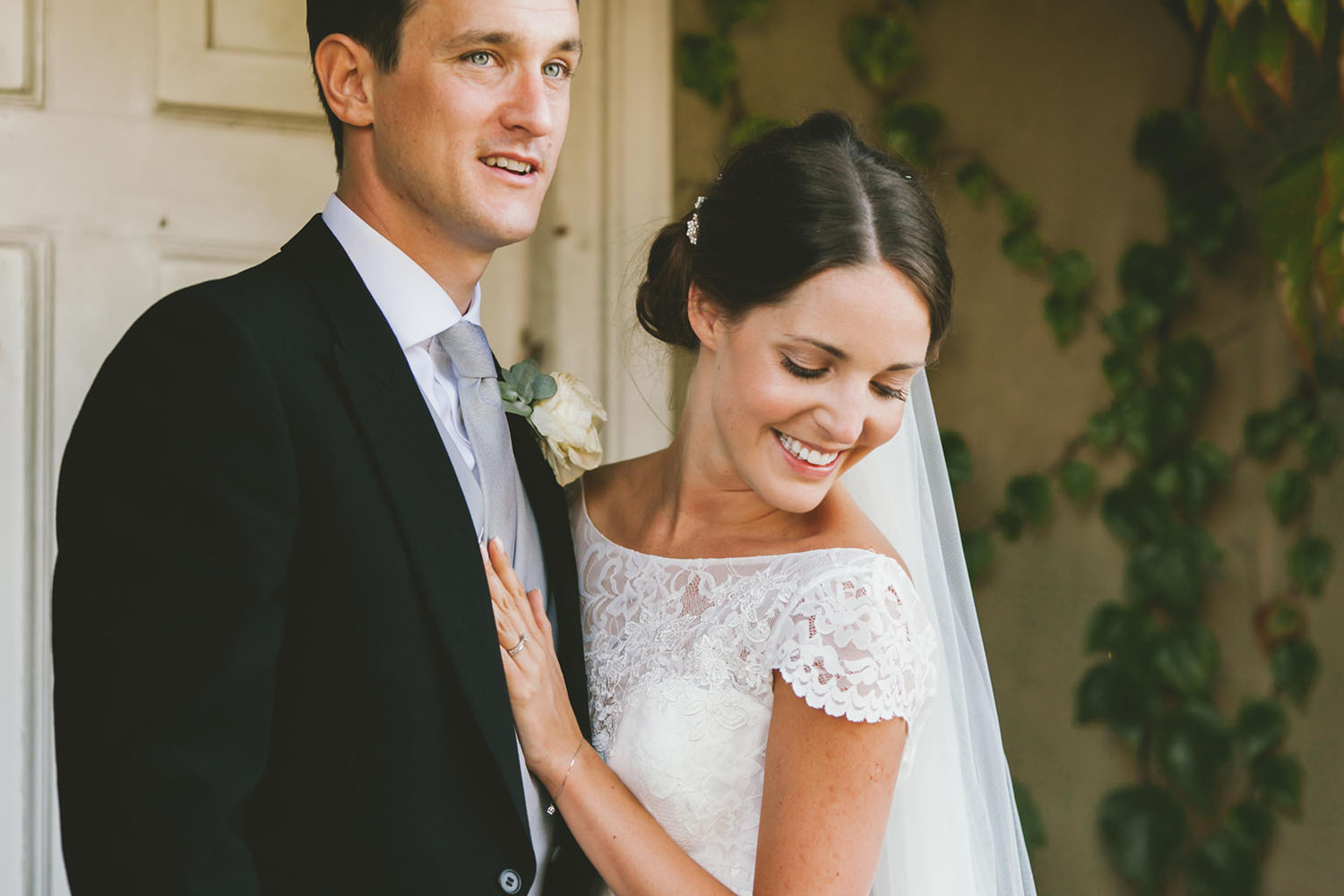 newly married couple stand at the entrance of their wedding venue after their reception