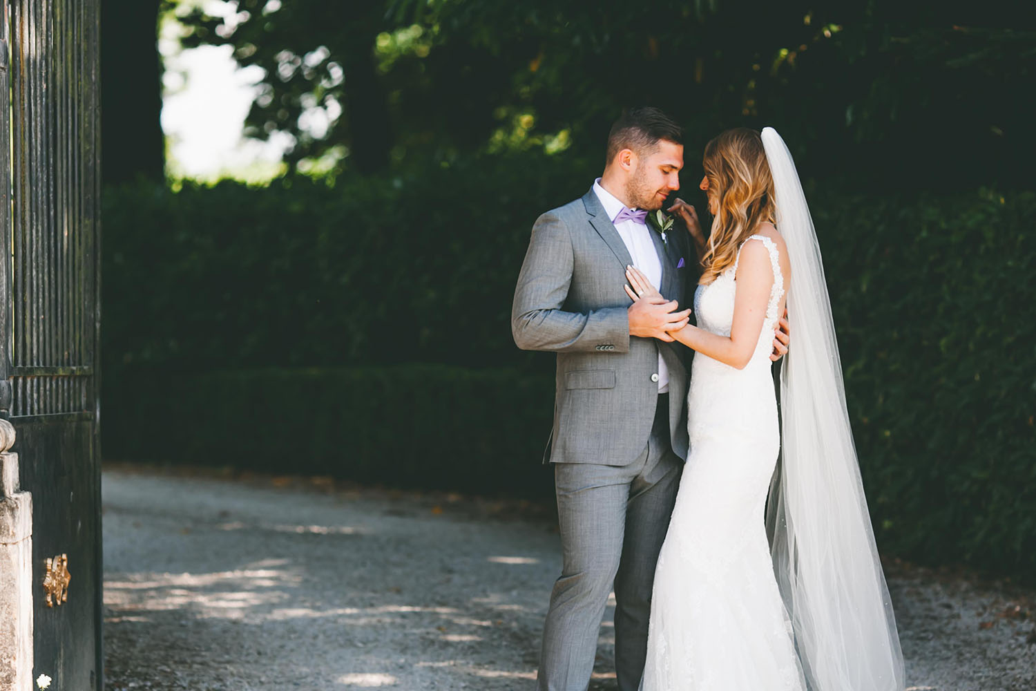 modern bride and groom posing in front of gate